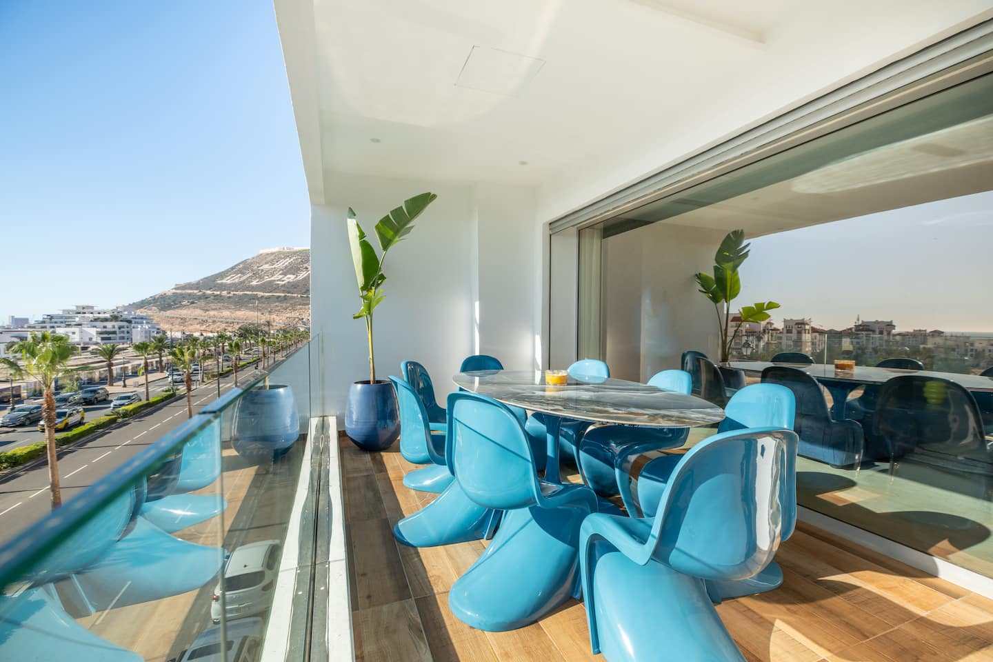 Terrasse avec table et chaises bleues face à l’océan, Agadir