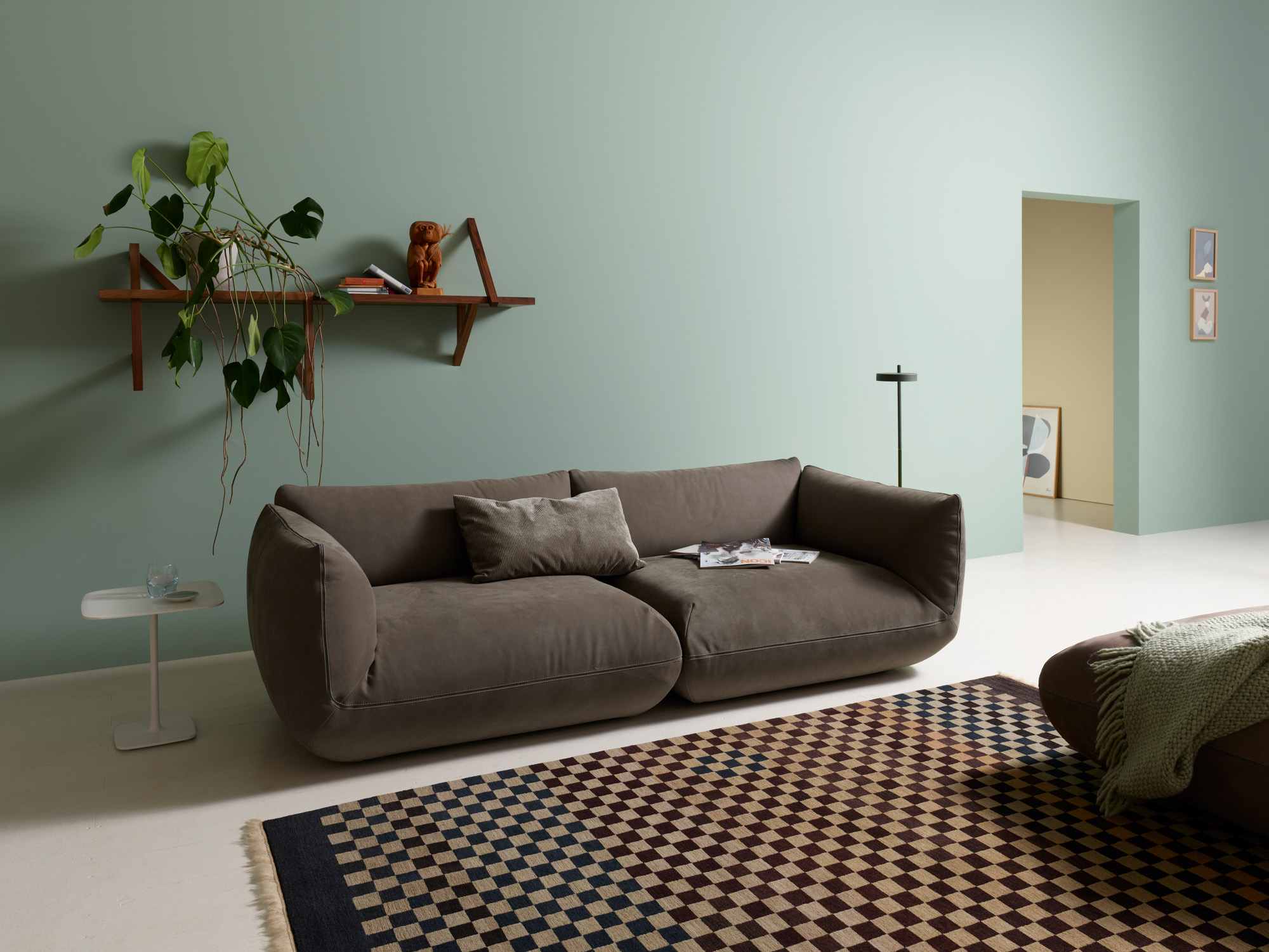 Canapé Jalis en cuir gris dans un salon aux murs vert pâle.